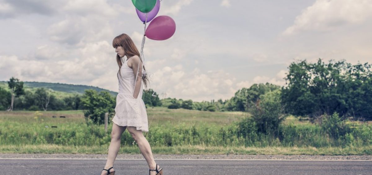 mujer que lleva globos