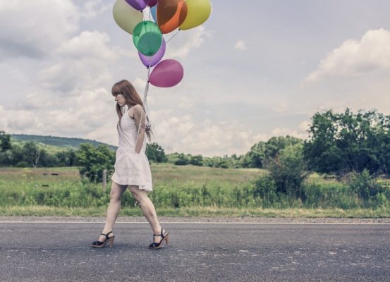 mujer que lleva globos